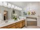 Bright bathroom with double sinks, a large mirror, a tub, and neutral tile at 7420 Cypress Grove Rd # 132, Orlando, FL 32819