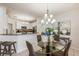 Bright dining room with a glass table, modern chandelier, and an open view to the kitchen at 7420 Cypress Grove Rd # 132, Orlando, FL 32819