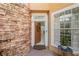Inviting front entry with tiled landing, stone facade and window providing ample sunlight at 7420 Cypress Grove Rd # 132, Orlando, FL 32819