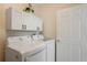 Convenient laundry room features white cabinets and a modern washer and dryer set at 7420 Cypress Grove Rd # 132, Orlando, FL 32819