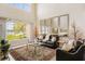 Elegant living room with high ceilings, large windows overlooking the lake, and comfortable seating at 7420 Cypress Grove Rd # 132, Orlando, FL 32819