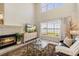 Cozy living room with a fireplace, large windows, and views of the scenic outdoors at 7420 Cypress Grove Rd # 132, Orlando, FL 32819