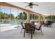 Outdoor patio area with tables and chairs, overlooking a refreshing pool and lush landscaping at 7420 Cypress Grove Rd # 132, Orlando, FL 32819