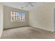 Cozy bedroom with plush carpet, a ceiling fan, and bright natural light from the large windows at 8213 Claire Ann Dr # 108, Orlando, FL 32825