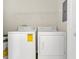 Convenient laundry room equipped with a washer, dryer, and storage shelving at 8213 Claire Ann Dr # 108, Orlando, FL 32825
