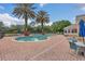 Community pool surrounded by brick patio, lush landscaping, lounge chairs, and umbrellas at 8213 Claire Ann Dr # 108, Orlando, FL 32825