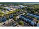 Aerial view of a neighborhood featuring townhomes with balconies, surrounded by lush greenery and neighborhood commerce at 861 Taramundi Dr, Oviedo, FL 32765
