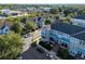 Townhomes with covered balconies, gray and blue exterior paint, dark shutters and parking spaces on a tree-lined street at 861 Taramundi Dr, Oviedo, FL 32765