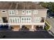 Exterior view of a three-story townhouse with three garage doors, and a neutral color palette at 861 Taramundi Dr, Oviedo, FL 32765