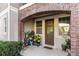 Inviting front porch with brick archway, potted plants, and ample natural light at 861 Taramundi Dr, Oviedo, FL 32765