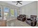Well-lit living room with door to outdoor patio, a brown leather sofa, recliner chair, and wood-look tile flooring at 861 Taramundi Dr, Oviedo, FL 32765