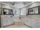Elegant bathroom featuring dual sinks, granite countertops, a soaking tub, and natural light at 9126 Shadowbrook Trl, Orlando, FL 32825
