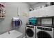 Functional laundry room with modern washer and dryer, ample storage, and utility sink at 9126 Shadowbrook Trl, Orlando, FL 32825