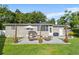 Backyard features a cozy stone patio with seating, a barbecue grill, and a pleasant fire pit for outdoor enjoyment at 715 Braidwood Ln, Orlando, FL 32803