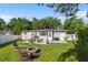The backyard boasts a stone patio with ample seating, a BBQ grill, and an outdoor fireplace for gatherings at 715 Braidwood Ln, Orlando, FL 32803