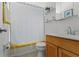 Bright bathroom with wood vanity, shower with striped curtain, and decorative wall art at 715 Braidwood Ln, Orlando, FL 32803