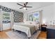 Beautifully decorated main bedroom featuring a black and white floral accent wall, ceiling fan and hardwood floors at 715 Braidwood Ln, Orlando, FL 32803