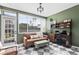Bright sun room features checkered floors, an entertainment center, and a cozy leather sofa and ottoman at 715 Braidwood Ln, Orlando, FL 32803