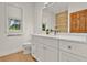 White bathroom boasts a vanity with marble counters and multiple windows at 10452 Log House Rd, Clermont, FL 34711