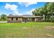 Charming single-story home with stone accents, large front yard, and mature landscaping at 10452 Log House Rd, Clermont, FL 34711