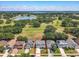 An aerial view of a two-story home with a well manicured lawn near a green space with a pond and lake at 1225 Greenley Ave, Groveland, FL 34736