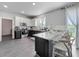 Bright kitchen features a gray and white color scheme, granite counters, and stainless steel appliances at 1225 Greenley Ave, Groveland, FL 34736