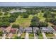 Aerial view of homes nestled among lush trees and green lawns, with a tranquil lake at 1225 Greenley Ave, Groveland, FL 34736