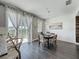 Bright dining area with modern light fixture, gray plank flooring, and view to backyard at 1225 Greenley Ave, Groveland, FL 34736