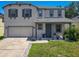 Charming two-story home featuring a well-manicured lawn, gray shutters, and a two-car garage at 1225 Greenley Ave, Groveland, FL 34736
