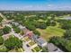 Aerial view showcases a neighborhood surrounded by lush greenery and lakes at 1225 Greenley Ave, Groveland, FL 34736