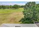 Back view of the house overlooks the lush green golf course and blue sky backdrop at 1225 Greenley Ave, Groveland, FL 34736