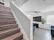 Staircase with wood steps leading to the living area with a ceiling fan and natural light at 1225 Greenley Ave, Groveland, FL 34736