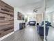 Inviting living room with a wood accent wall, large TV, and comfortable blue sofas at 1225 Greenley Ave, Groveland, FL 34736