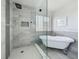 Bright bathroom showcasing a modern shower and standalone tub with stylish fixtures, complemented by a window for natural light at 1225 Greenley Ave, Groveland, FL 34736