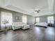 Expansive main bedroom with tray ceiling, wood-look floors, and cozy seating area at 1225 Greenley Ave, Groveland, FL 34736