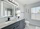 Elegant bathroom with dual sinks, granite countertops, modern faucets, and a decorative mirror with stylish light fixtures at 1225 Greenley Ave, Groveland, FL 34736