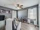 Cozy living room with neutral-toned walls, ceiling fan, and a large projection screen at 1225 Greenley Ave, Groveland, FL 34736