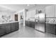 Well-lit kitchen featuring stainless steel appliances, gray cabinets, and marble countertops at 1225 Greenley Ave, Groveland, FL 34736