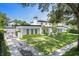 Stunning modern home with manicured lawn, dark trim, and lush landscaping at 1581 Forest Ave, Winter Park, FL 32789