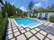 Beautiful pool surrounded by a patterned deck and manicured landscaping, perfect for outdoor relaxation at 1581 Forest Ave, Winter Park, FL 32789