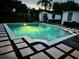 Backyard pool with modern tile, a lounge area, and manicured landscaping at 1581 Forest Ave, Winter Park, FL 32789