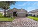 Charming single-story home featuring a brick driveway, well-maintained landscaping, and a two-car garage at 528 Bridgeford Crossing Blvd, Davenport, FL 33837