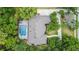Aerial view of a home with a large pool, lush landscaping, mature trees, and an extended driveway at 554 Estates Pl, Longwood, FL 32779