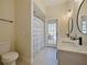 Bathroom features double sinks, shower with blue and white curtain, and a glass door to outside at 554 Estates Pl, Longwood, FL 32779