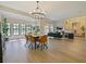 Open dining and living space, features a large chandelier and lots of natural light from large windows at 554 Estates Pl, Longwood, FL 32779