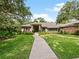 Inviting single-story home with walkway leading to the front door, surrounded by a well-manicured lawn and landscaping at 554 Estates Pl, Longwood, FL 32779