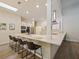 Modern kitchen with stainless steel appliances, long breakfast bar, white cabinets, and a stylish range hood at 554 Estates Pl, Longwood, FL 32779