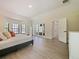 Bright main bedroom with light hardwood floors, large windows, and french doors leading to a patio at 554 Estates Pl, Longwood, FL 32779