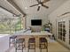 Outdoor kitchen and bar features a long countertop, stools, and a ceiling fan at 554 Estates Pl, Longwood, FL 32779