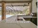 Close up view of outdoor kitchen with large countertop, sink, and drink refrigerator, with a view of the pool at 554 Estates Pl, Longwood, FL 32779